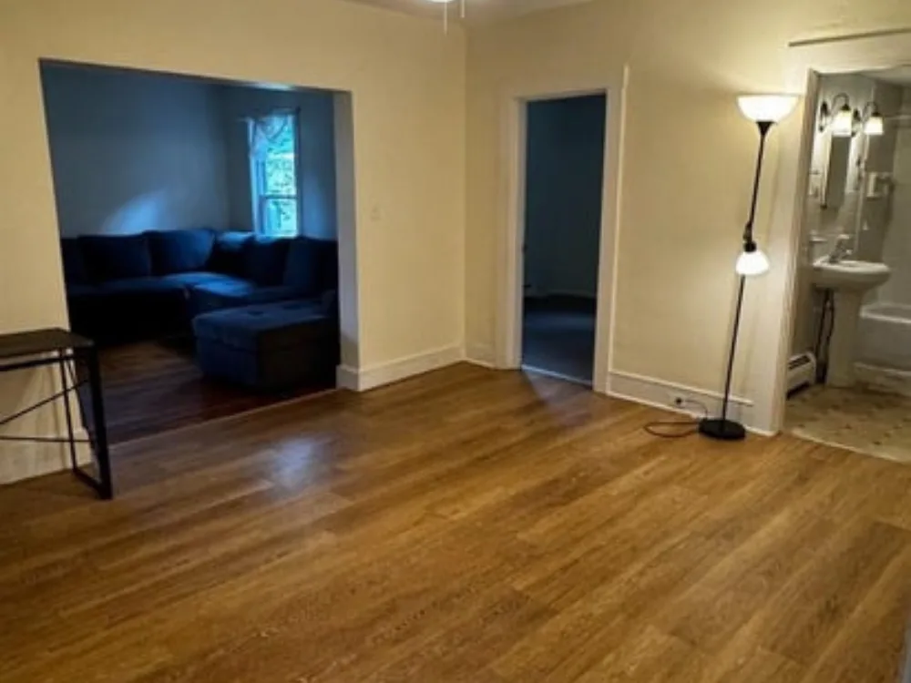 Residential cleaning service completed in an empty living room with clean wood flooring
