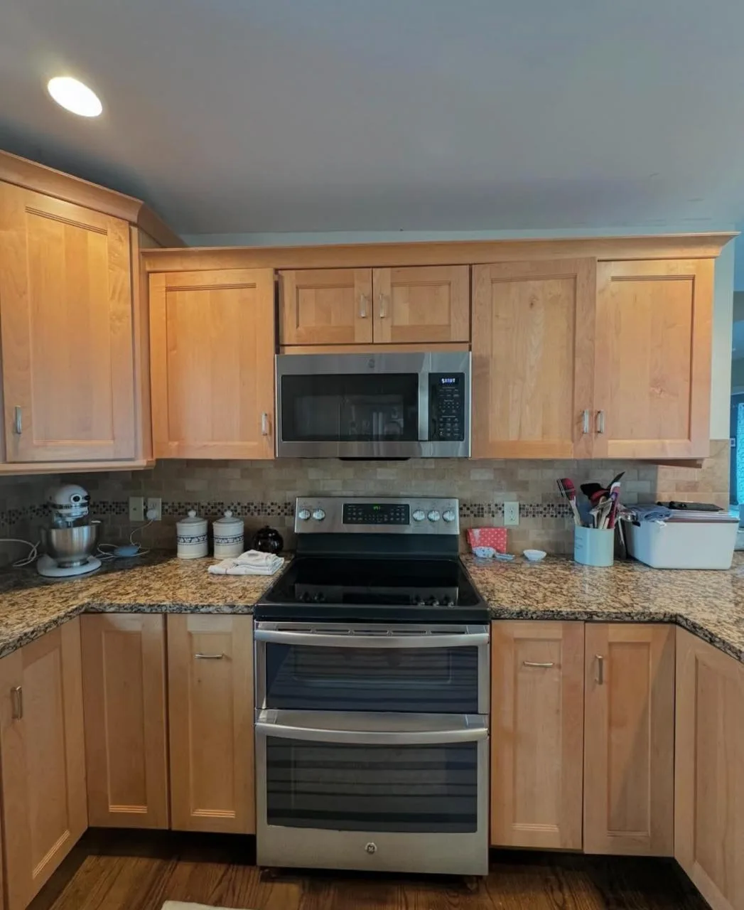 Clean wooden cabinets and stainless steel appliances organized after a comprehensive kitchen deep cleaning.