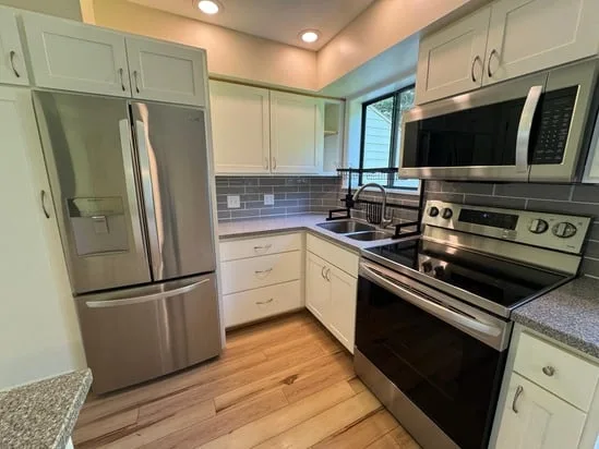 Stainless steel refrigerator and modern cabinets showcased after a complete kitchen deep cleaning.